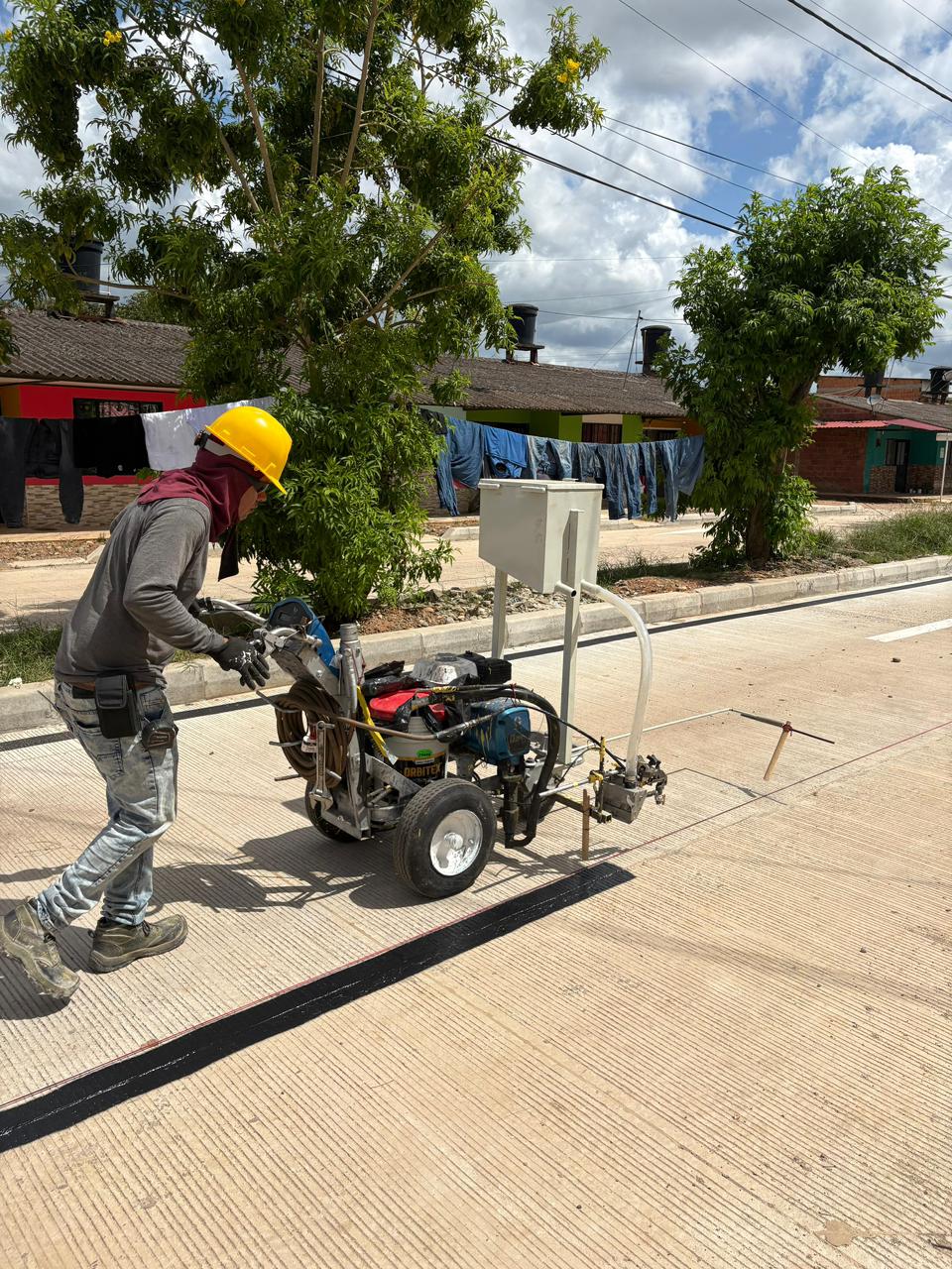 Operario realizando demarcación vial con máquina profesional en Villavicencio, Meta, Colombia